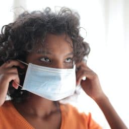 woman putting a face mask on