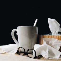 A mug, some tissues and a pair of glasses.