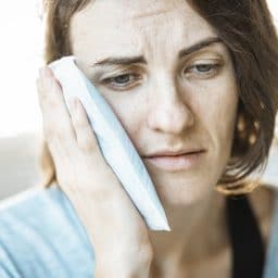 Woman with an ice pack on her ear.