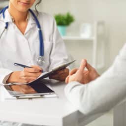 A patient consults with an allergist in an office.