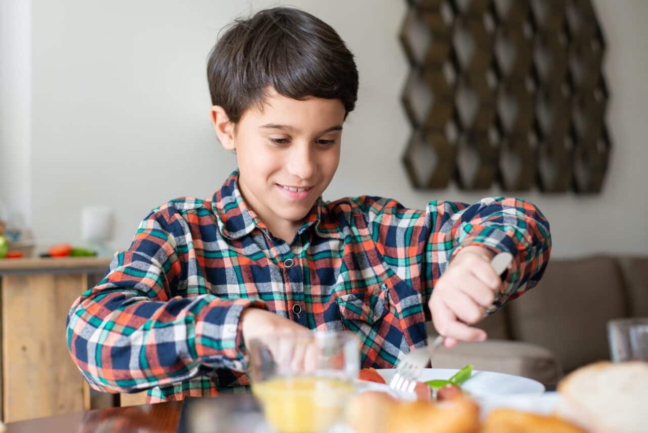 Young boy eating breakfast at home.