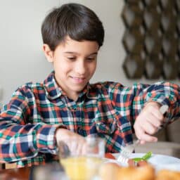 Young boy eating breakfast at home.