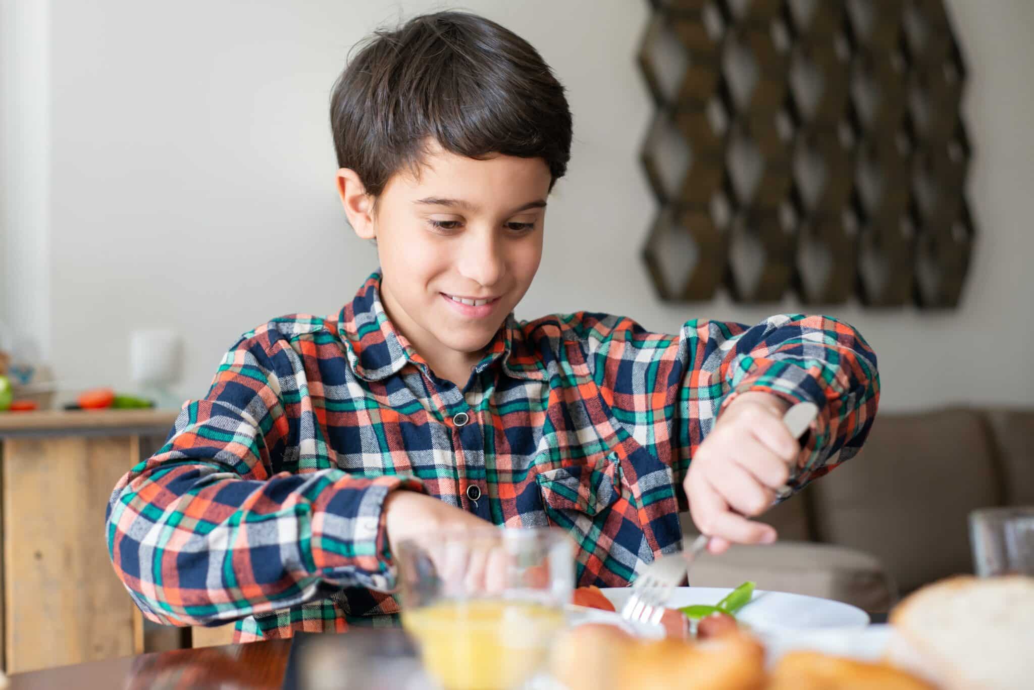 Young boy eating breakfast at home.