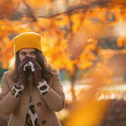 Woman blows nose in the fall