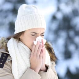 Woman in the snow blowing her nose