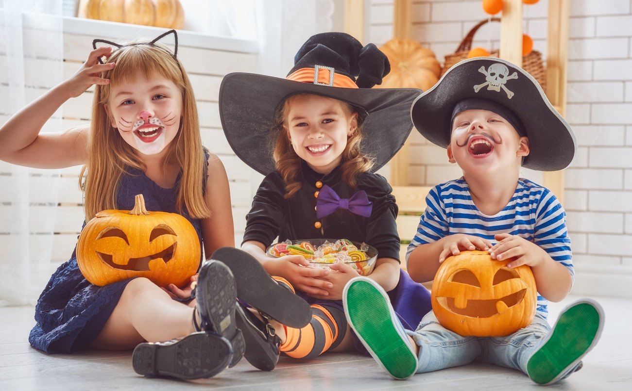 Three young kids in Halloween costumes