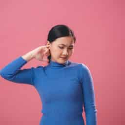 Woman scratches ear