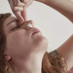 Young woman stop nose blood with cotton wool swabs