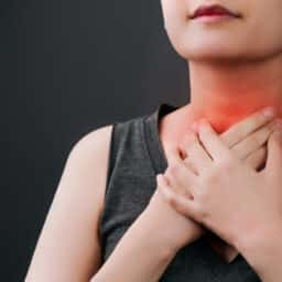 Woman holding her red, sore throat