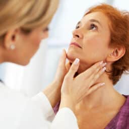 Doctor examining her patient's throat