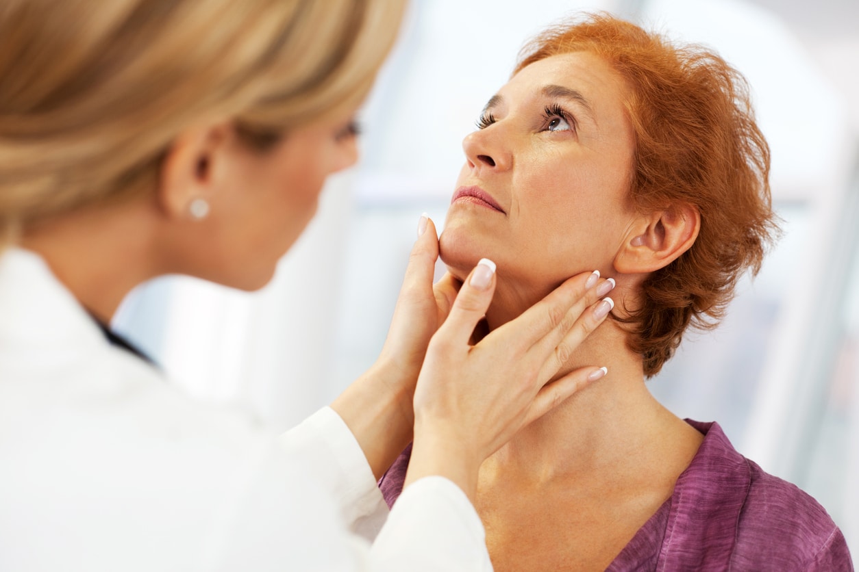 Doctor examining her patient's throat.