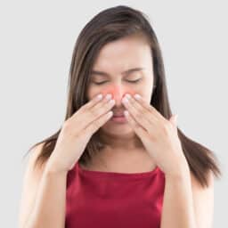 Woman touching her red sinuses
