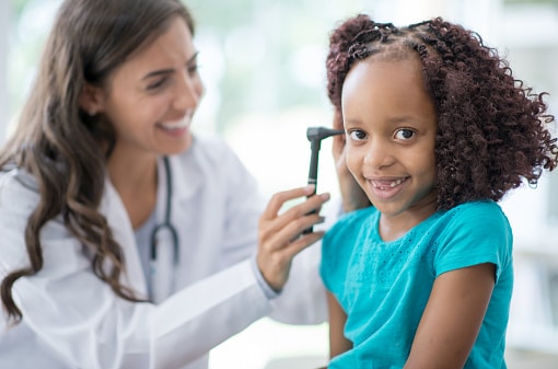Young girl smiling in her ear exam.