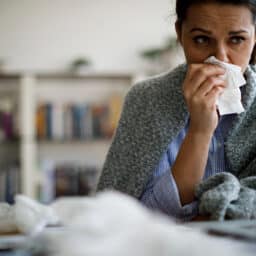 Woman blowing her nose.